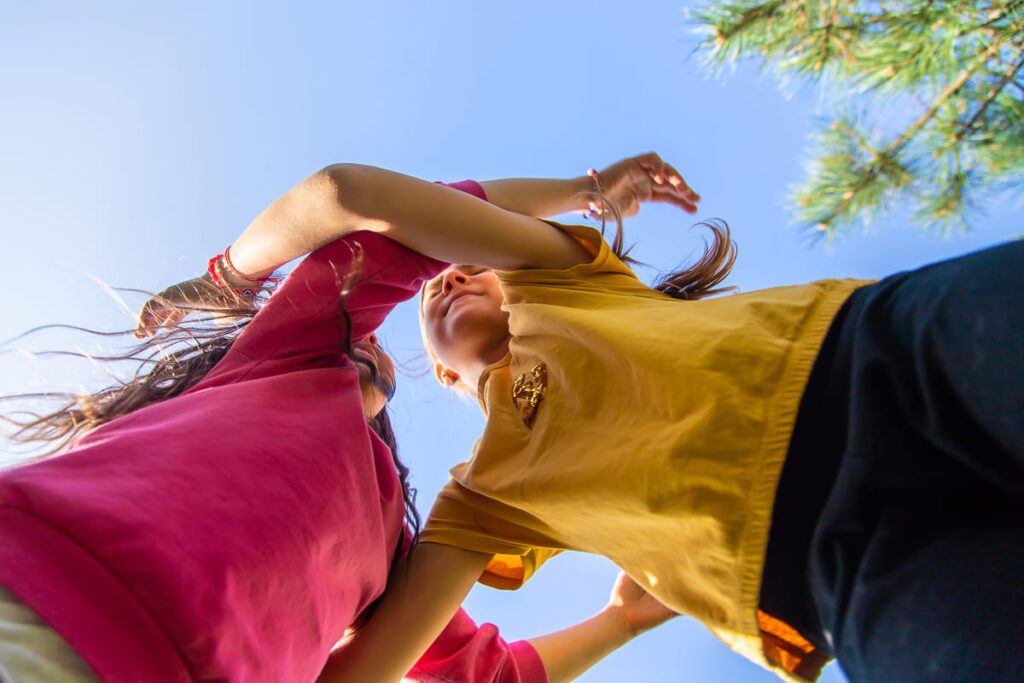 Docente explicando normas de juego seguro a un grupo de alumnos para prevenir accidentes en el recreo.