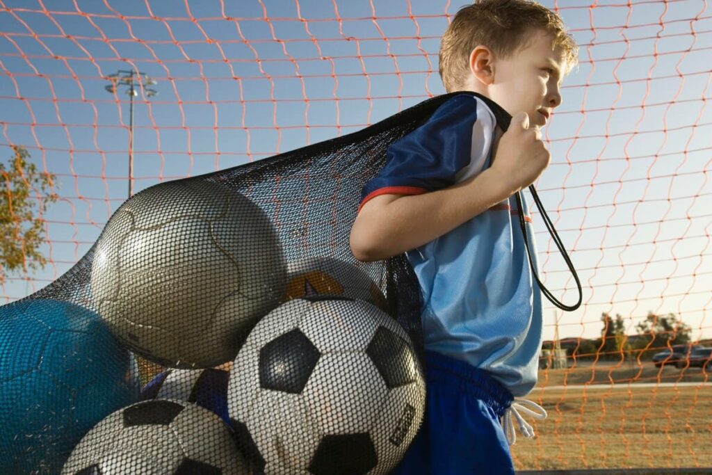 Grupo de niños participando en actividades deportivas en extraescolares fomentando el compañerismo.