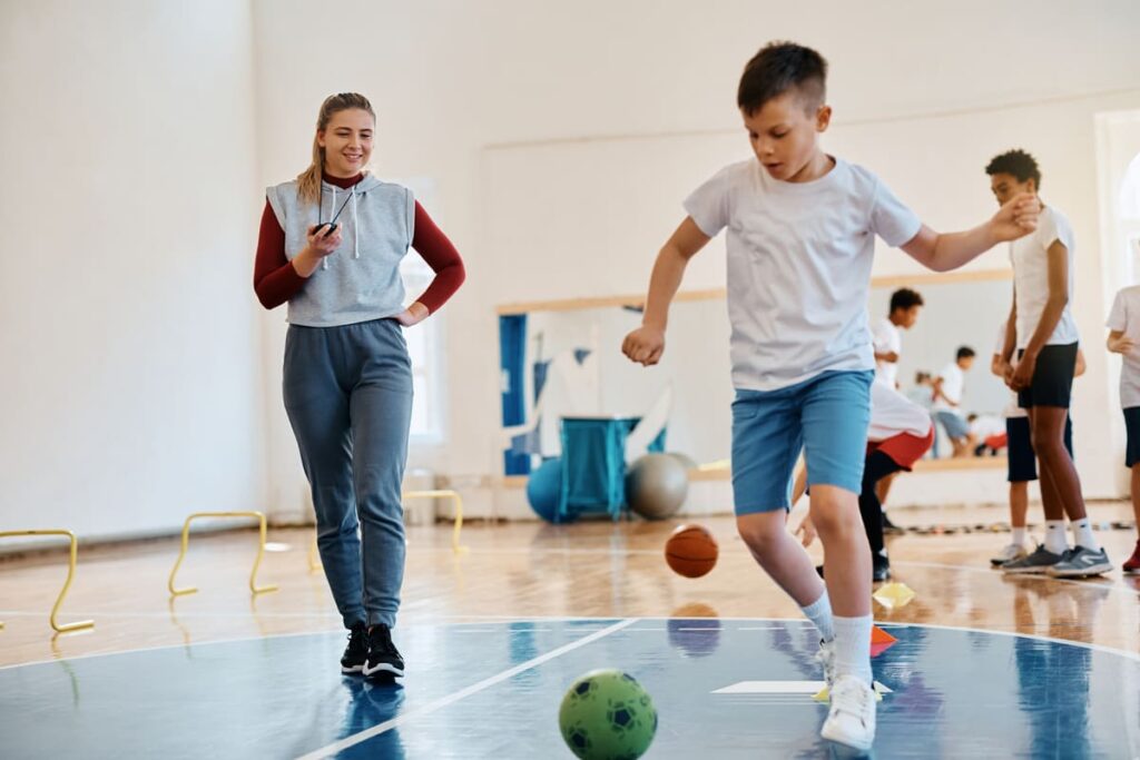 Docente organizando dinámicas de sesiones deportivas en espacios pequeños o gimnasios interiores.