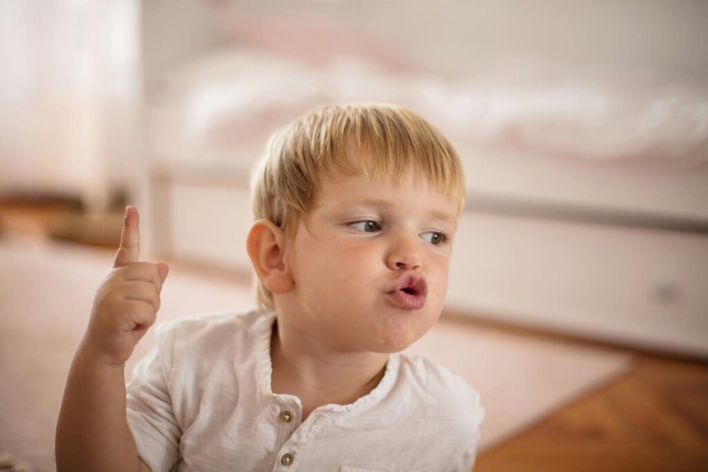 Niño pequeño intentando comunicarse para ilustrar los hitos de alerta en el lenguaje en niños.